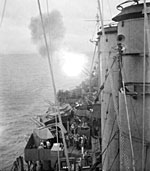 The cruiser HMAS Shropshire bombarding Japanese positions at Balikpapan, Borneo, on 30 June 1945