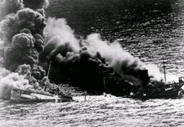 Broken in two by a torpedo, this tanker sinks beneath the waves. Torpedoes with magnetic pistols exploded beneath the target, breaking the hull in two