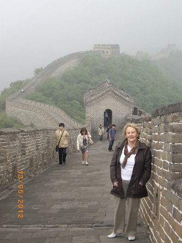 Denise on the Wall at Bejing, with the wall stretching into the distance