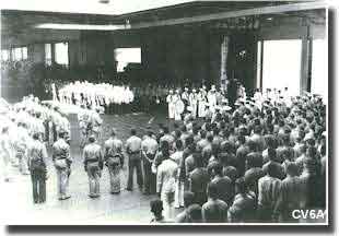 Officers and men gather in Enterprise's hanger to bury the 44 dead from the Battle of Santa Cruz 27 October 1942